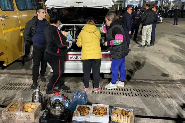 Volunteers prepare hot drinks and snacks for Russians arriving in Kazakhstan on a square outside the railway station in the city of Uralsk