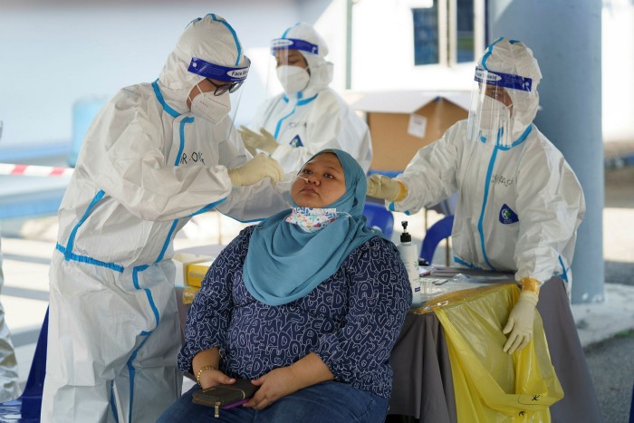 A medical worker collects a swab sample for a Covid-19 test in Shah Alam, near Kuala Lumpur