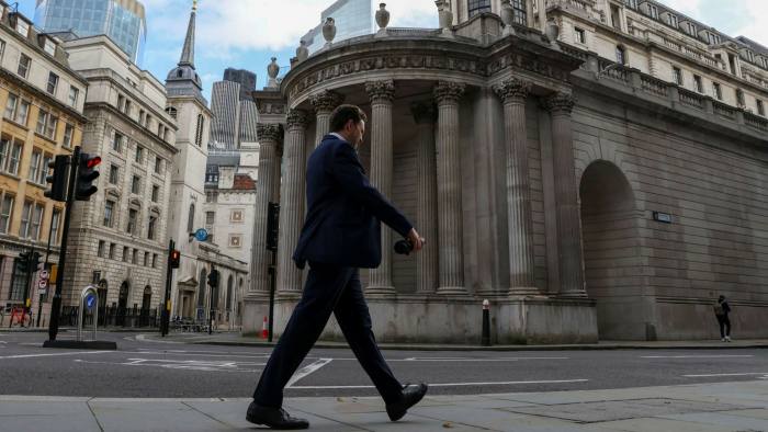 An office worker passes the Bank of England in the City of London