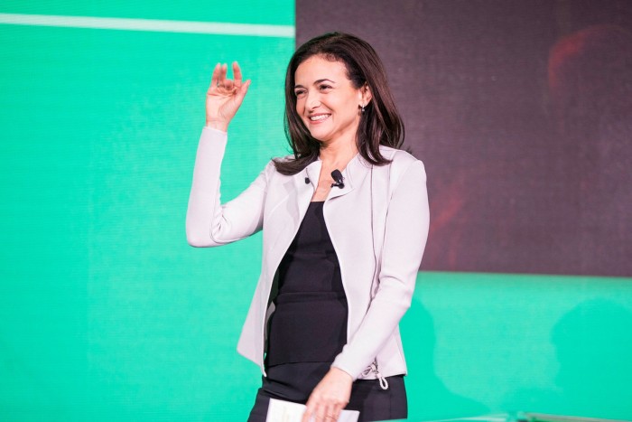 Meta COO Sheryl Sandberg waves from the stage at at conference