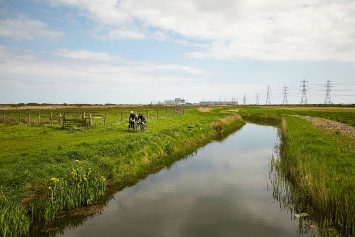 Cycling by a waterway among green fields