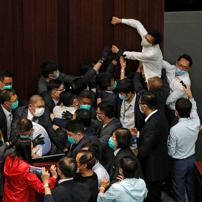 Pro-democratic legislator Eddie Chu Hoi-dick scuffles with security guards and pro-China legislators during a legislative council meeting in May