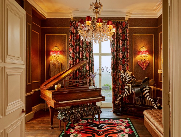 The piano room, with Lavinia curtains, Kitty wallcovering and piano stool upholstered in Lolana velvet