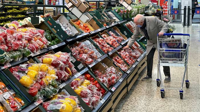 A customer shops for food items inside a Tesco supermarket store