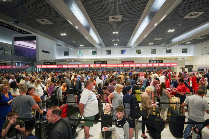 Passengers queue for check-in at Manchester Airport’s Terminal 2