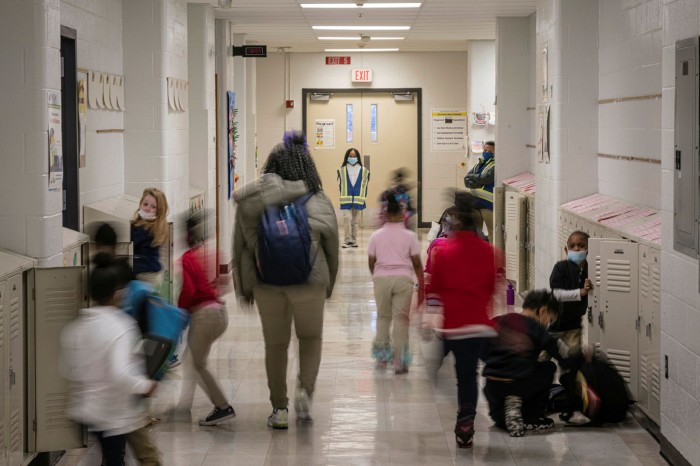 A child acting as hallway monitor watches as children move about a hallway at Carter Traditional Elementary School in Louisville, Kentucky