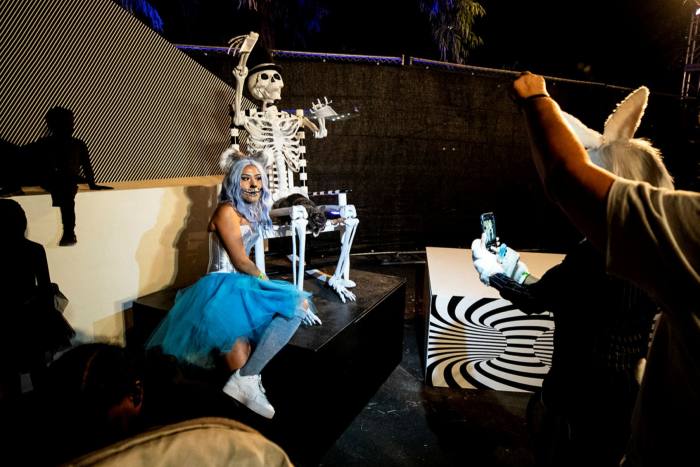 A guest poses during her tour of an open-air Halloween event in Los Angeles