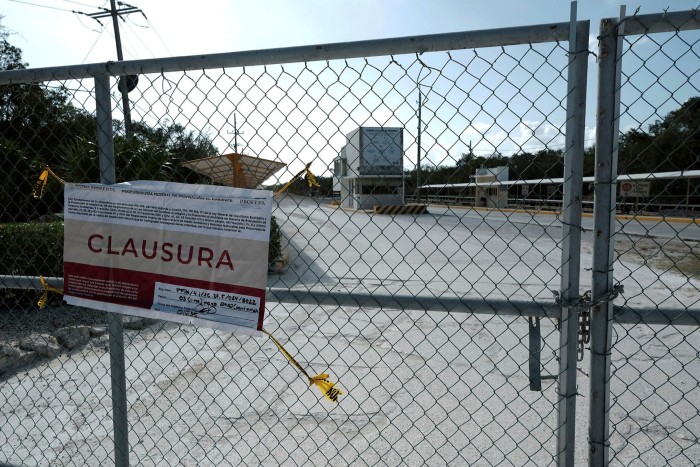 A sign reading ‘Closure’ hangs on a fence at the entrance of the limestone mining by Vulcan Materials in Calica, in Quintana Roo state, Mexico