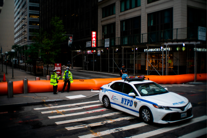 NYPD officers stand guard next to barriers used to prevent flooding at the South Street Seaport as New York City braced for tropical storm Isaias in August 2020