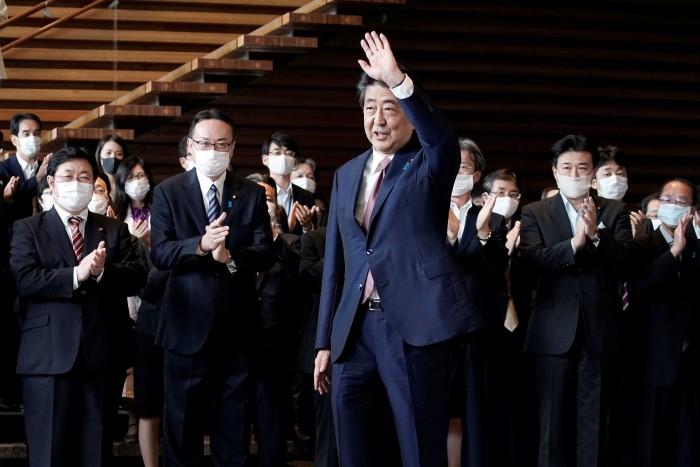 Outgoing prime minister Shinzo Abe waves before leaving office on September 16, 2020, in Tokyo