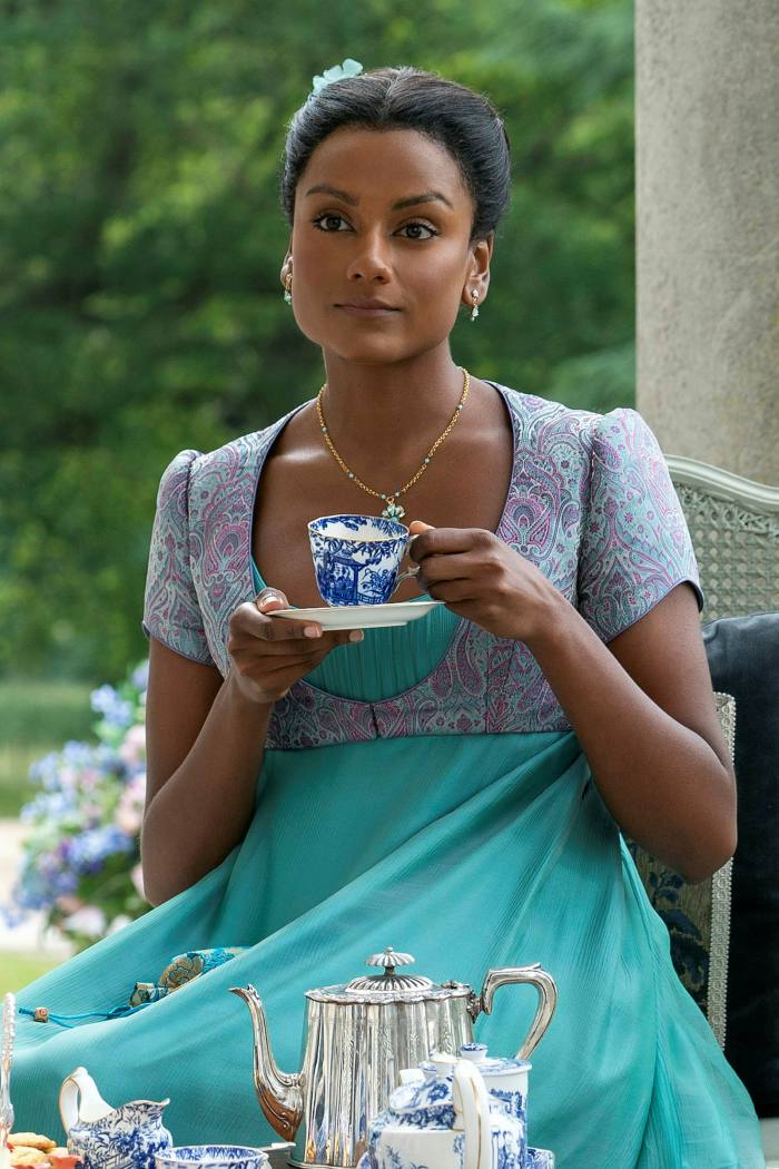A woman drinks tea from a cup and saucer