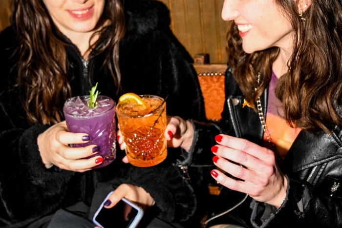 Two women, each holding non-alcoholic drinks