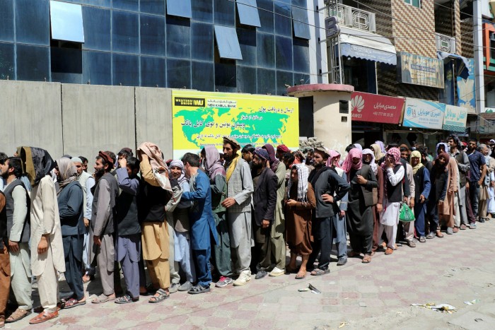 Afghans wait outside Kabul Bank on August 25