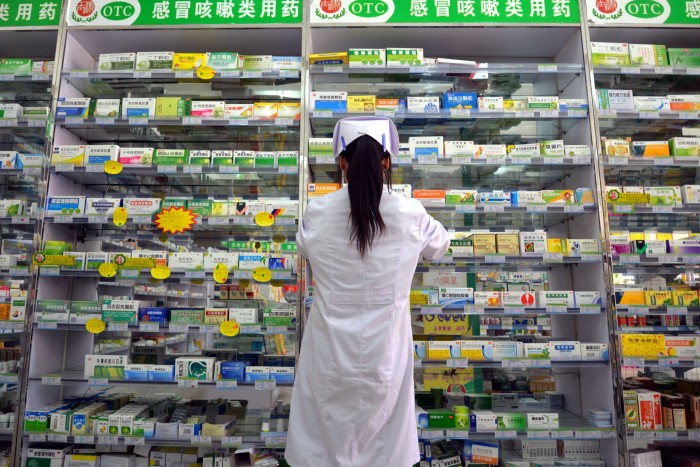 Een apotheker deelt medicijnen uit in een drogisterij in Linyi, China