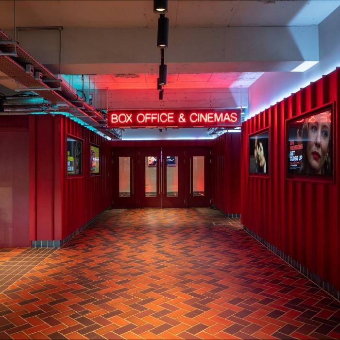 A corridor in BFI Southbank, with a red neon sign and film posters on the walls