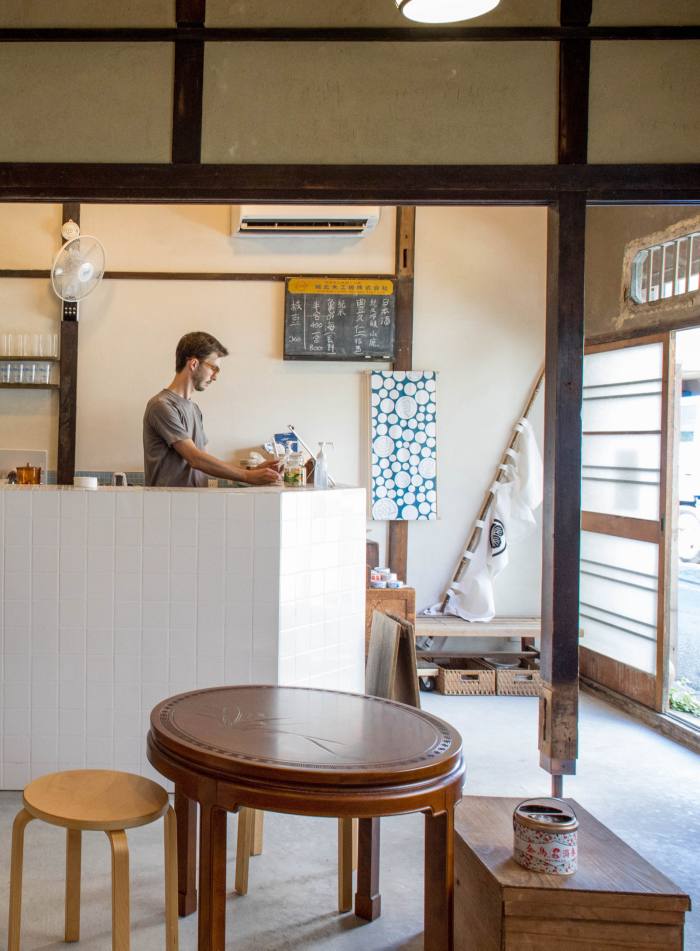 US urban activist and writer Sam Holden behind the bar in the building next to Inari-yu that he helped transform into a community space for the sento