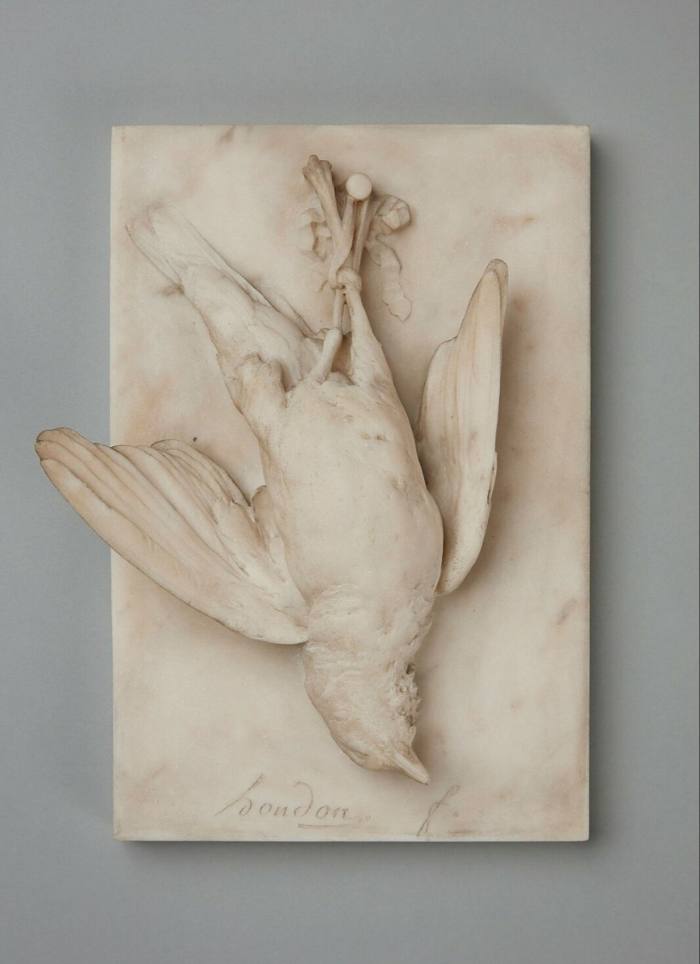 A marble statue of an inverted bird with outstretched wings