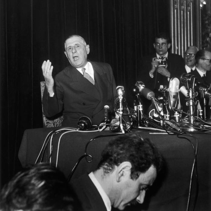 Black and white photo of Charles de Gaulle speaking at a press conference