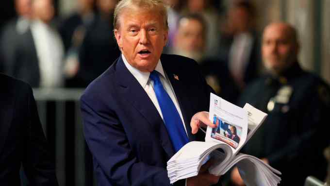 Donald Trump holds up press clippings