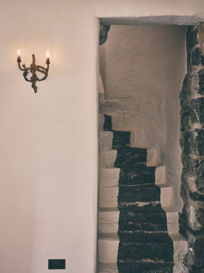 The front stairs to one of the attic rooms. Many of the vintage wall sconces were sourced by Tallulah
