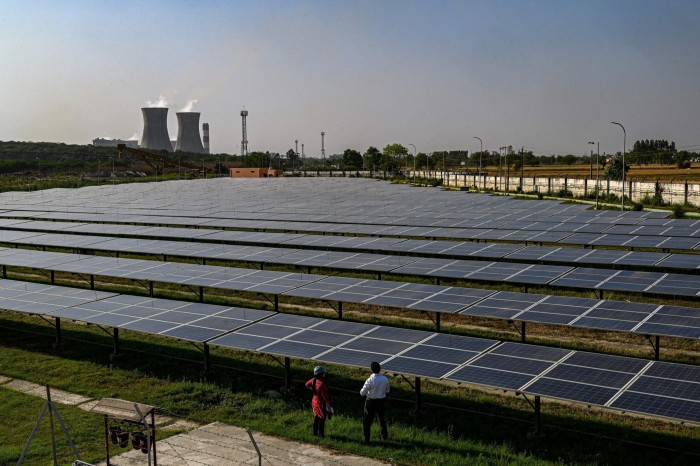 a vast tract of land near a power plant is covered with solar panels