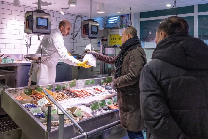 Customers buying fish at SeeWoo supermarket