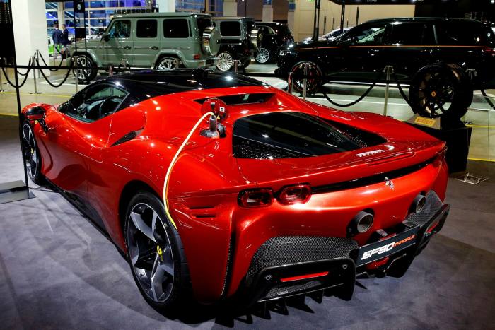A charging cable is plugged into a Ferrari SF90 Stradale hybrid sports car at the Auto Zurich Car Show in Zurich, Switzerland in November 2021 