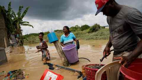 Pessoas estão tentando salvar seus pertences na parte inundada do Equador