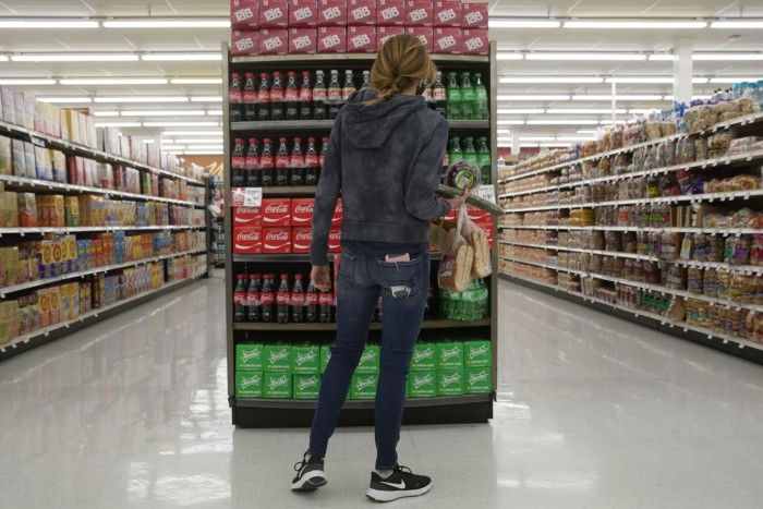 A shopper looks at a display of Coca-Cola drinks at a store