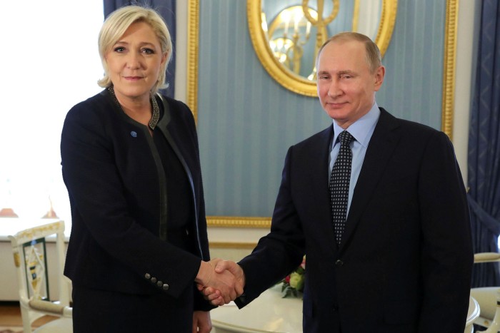 Russian President Vladimir Putin shakes hands with Marine Le Pen in 2017