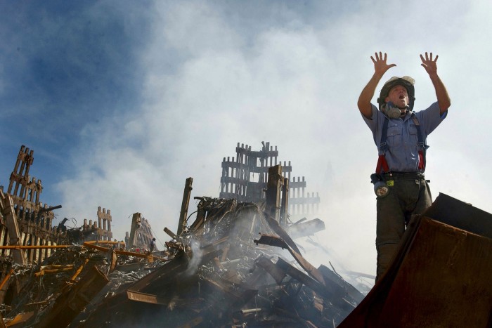 A New York City fireman stands by the rubble of the World Trade Center