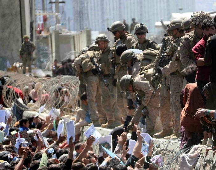 Los afganos están luchando fuera del aeropuerto de Kabul en Afganistán el 26 de agosto para llegar a las fuerzas armadas extranjeras con el fin de mostrar su autorización para huir del país.