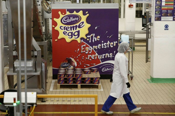 An employee passes spools of foil used for wrapping Cadbury Creme Eggs in the Bournville Cadbury factory