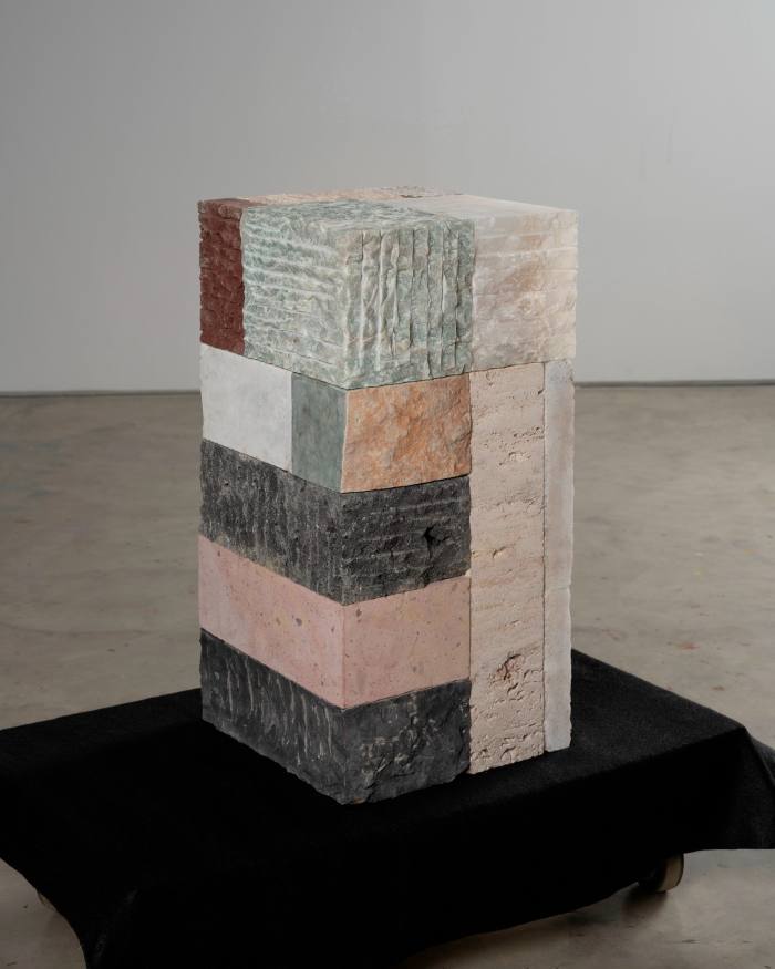 A cuboid sculpture made of bricks of different materials