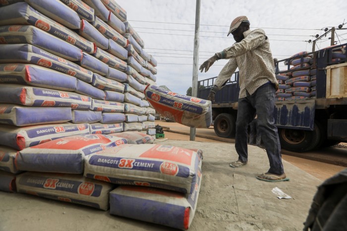 A man drops a bag of Dangote cement while unloading a truck in Abuja, Nigeria