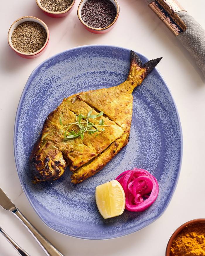 Palometa tandoori, un pez plano, en un plato azul cielo en Bombay Dreams