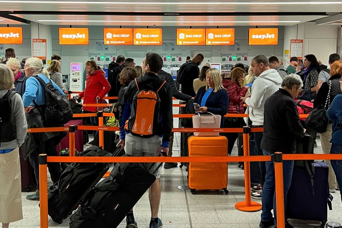 Holidaymakers queue in the North Terminal at Gatwick airport near London, UK