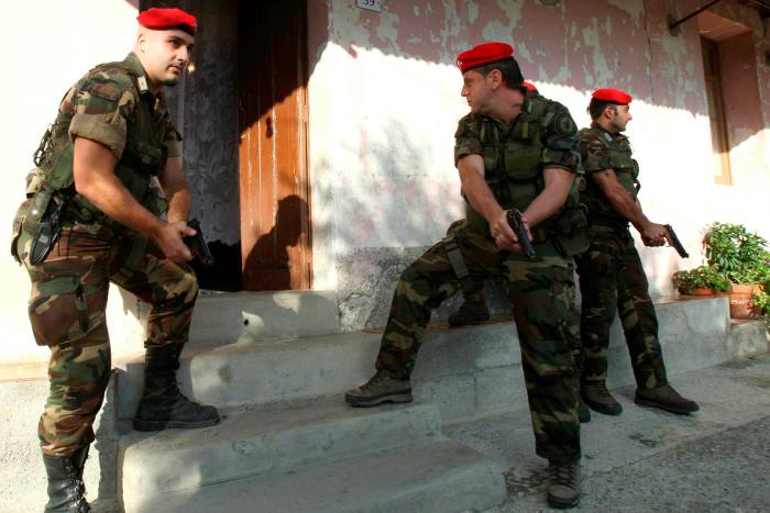 Three armed Italian policemen prepare to enter an ‘Ndrangheta Mafia bunker in Siderno in 2008