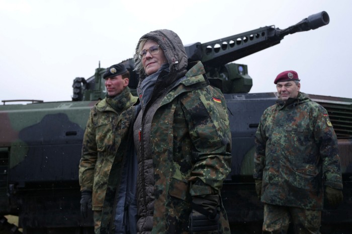 German Defence Minister Christine Lambrecht stands next to a Puma infantry fighting vehicle 