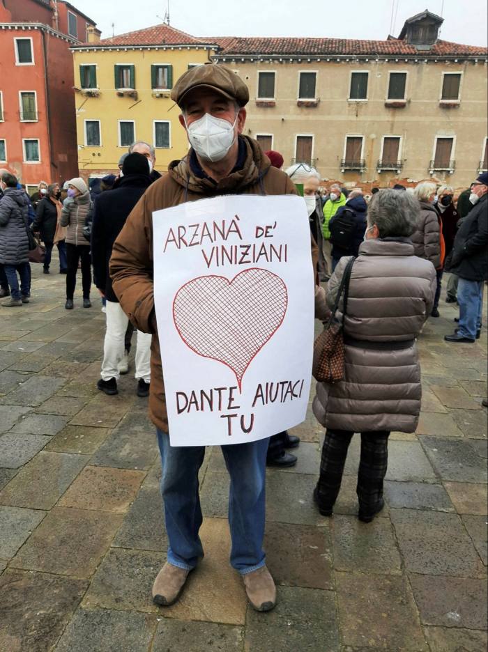 A man with a facemask carried a sign with a large heart drawn on it