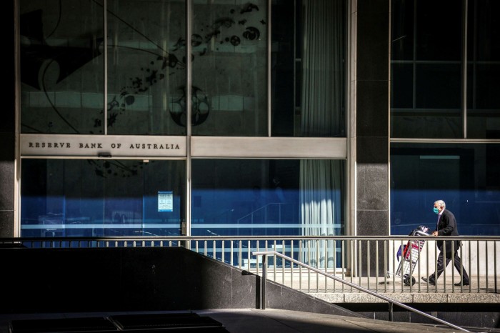 A man pushes a trolley towards the Reserve Bank of Australia office in Sydney