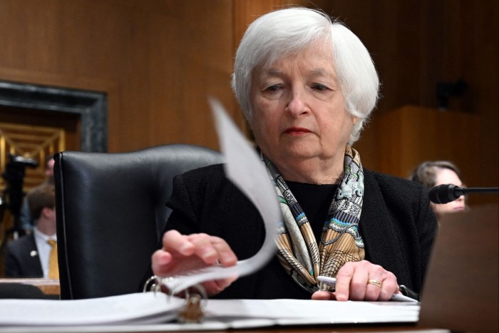 Janet Yellen turns a page in a lever arch file while sitting in the Senate