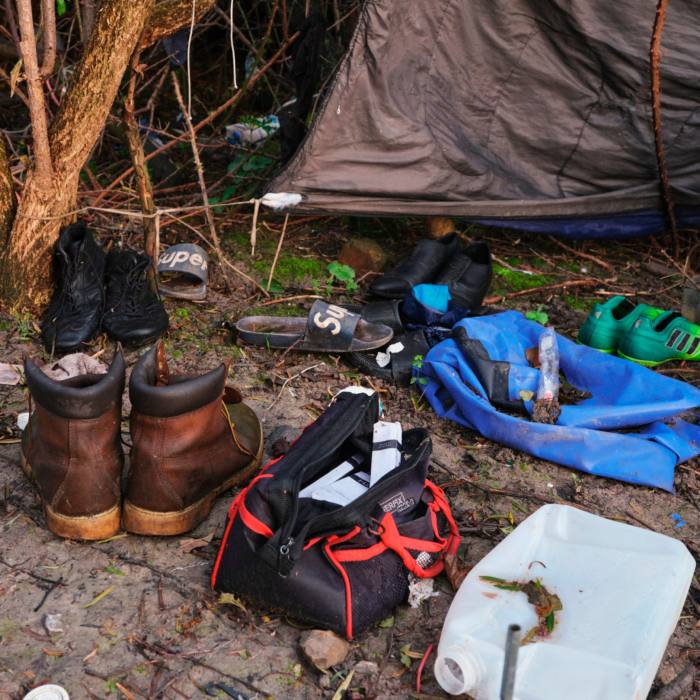 Boots, a bag and empty water container outside a tent