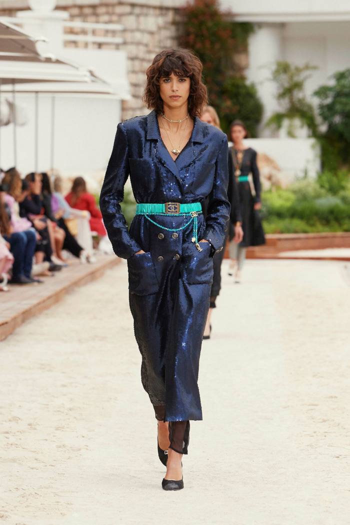 A model in a dark blue belted coat dress