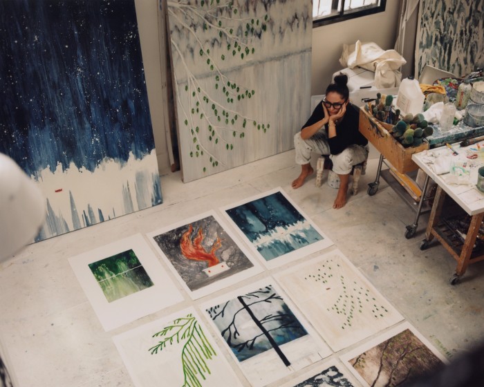 Suzy Murphy sits with a selection of monoprints in her London studio