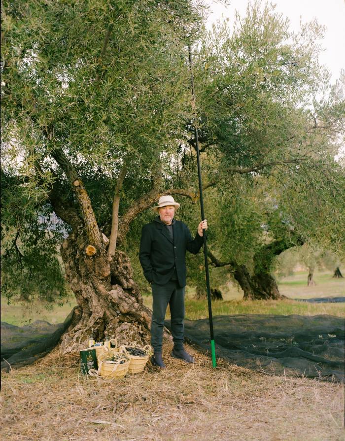 Philippe Starck stands in front of an olive tree at the LA Organic Experience olive oil farm in Andalusia