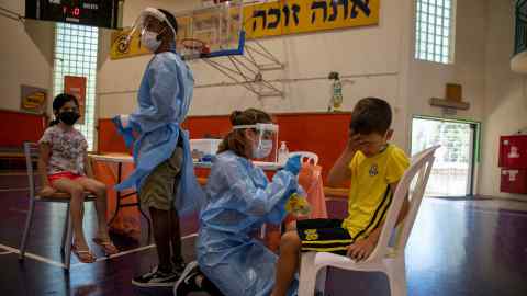Medics test children for coronavirus at a testing centre in Binyamina, Israel