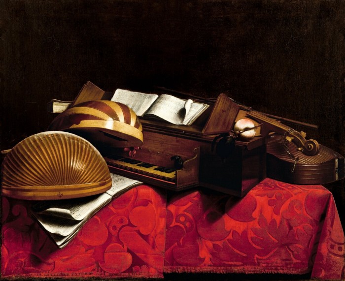 A mandola, lute, cittern and small piano-type instrument sit on a red silk damask-covered tabletop 
