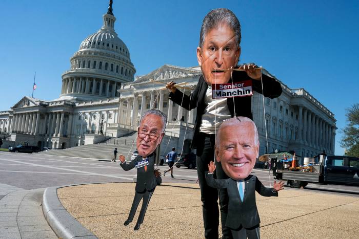 A climate change demonstrator mocks West Virginia Senator Joe Manchin, who has blocked President Joe Biden’s domestic agenda, at the Capitol in Washington