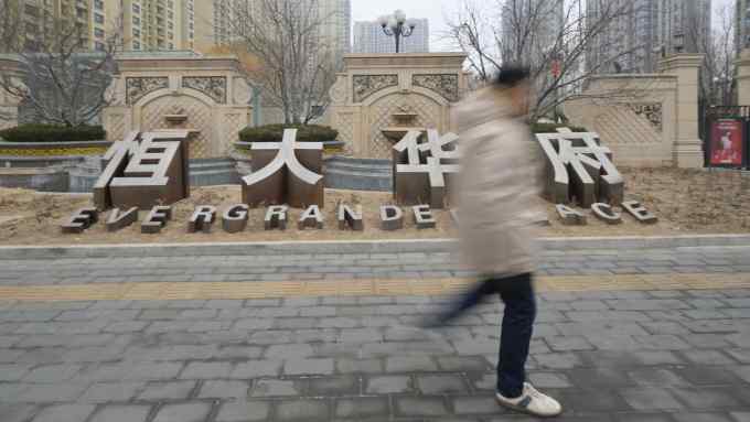 A man walks past an Evergrande Group residential complex called Evergrande Palace in Beijing